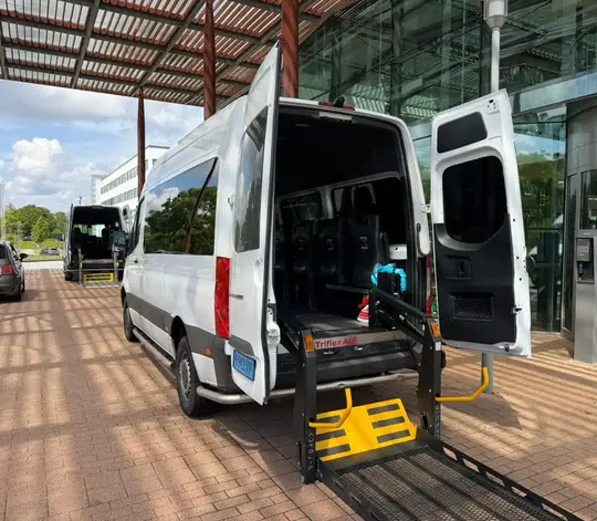 Professionele rolstoeltaxi chauffeur helpt klant in Delft